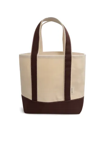 A cream canvas tote bag with dark brown handles, on a white background